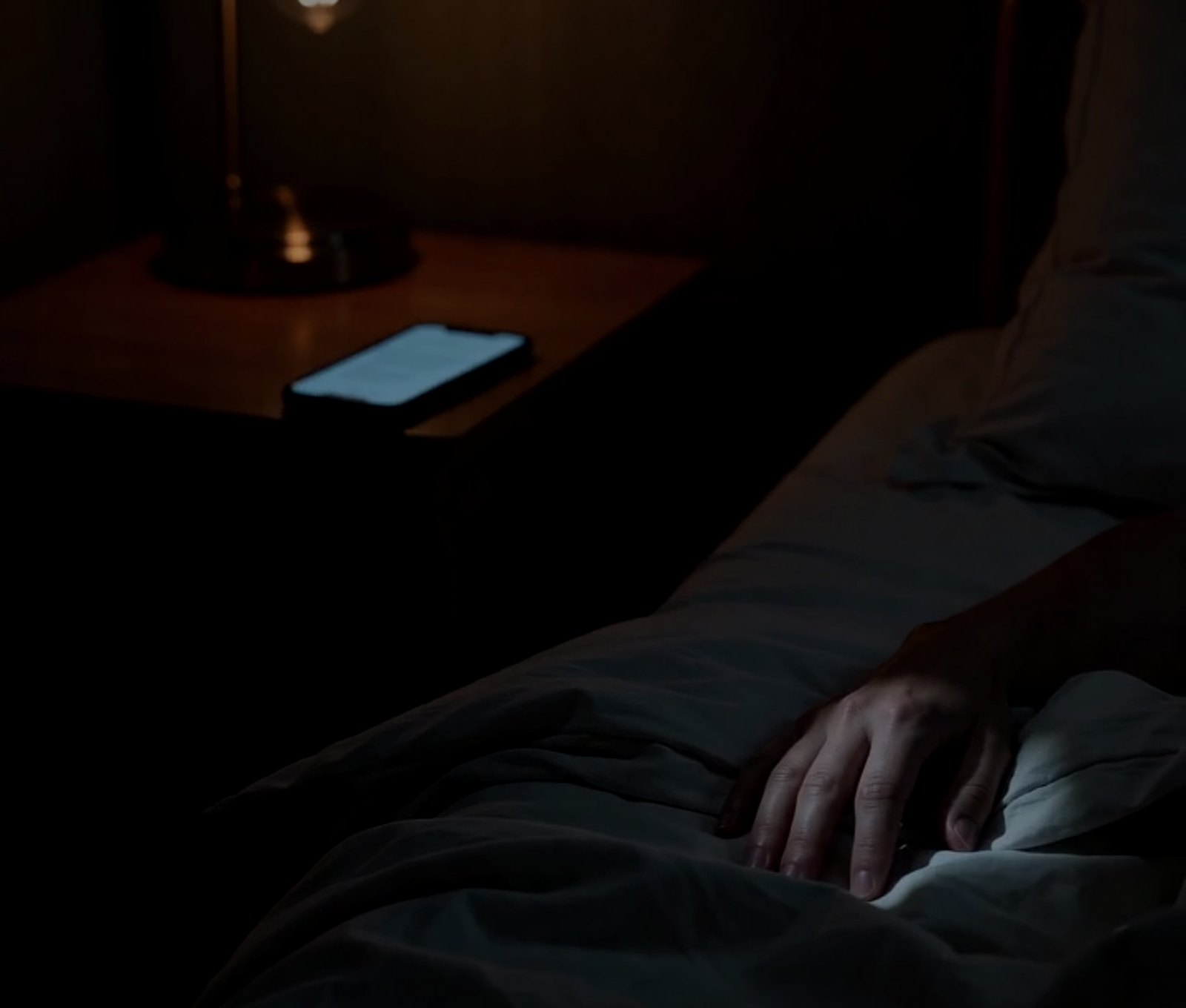 A dark bedroom at 3 a.m., a phone face-down on the mattress.